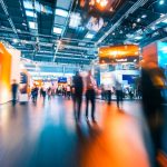 Dynamic business expo with a lively trade show floor featuring bustling crowds and vibrant booths.
